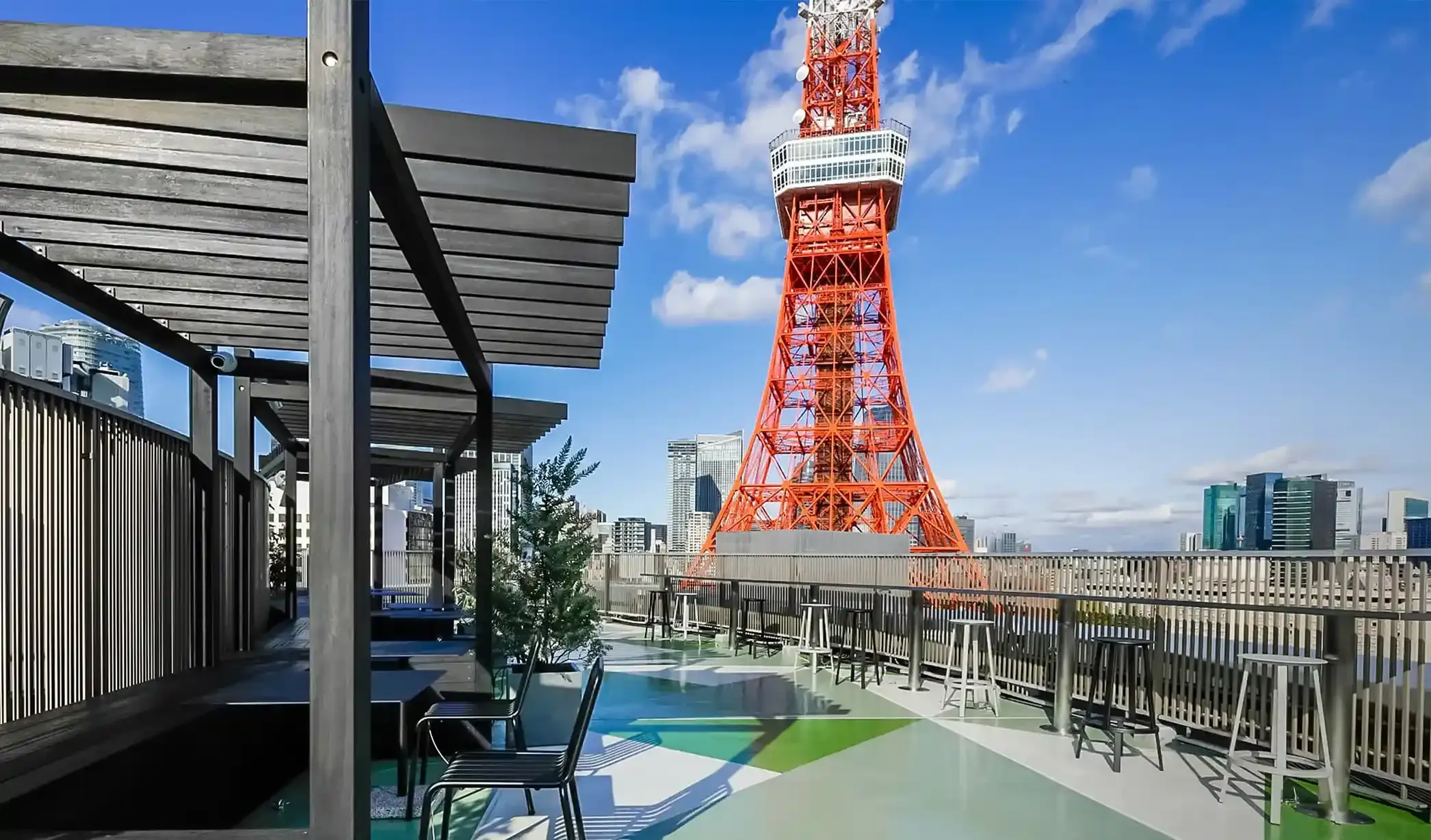 東京タワーを間近に望む屋上テラス。テーブルと椅子が配置され、開放的な空間が広がる。